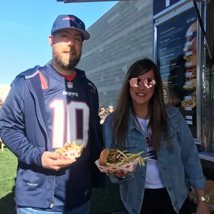 a man and a woman standing in front of a food truck