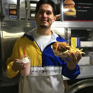 a man holding a sandwich and a drink