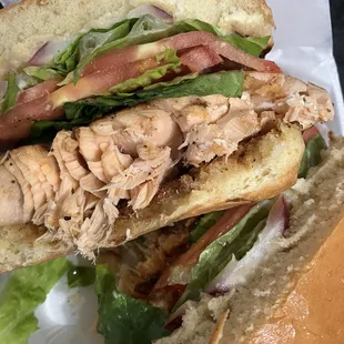 Slapping Salmon Sandwich Blackened Salmon on Brioche Bun, Lettuce, Tomato, Red Onion, and Cilantro Lime Aioli