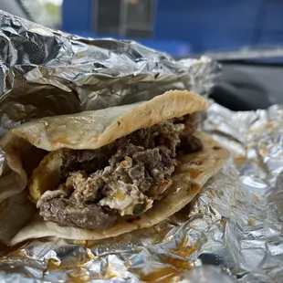 a beef sandwich wrapped in foil