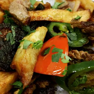 Peruvian Fries - Prime rib with tomatoes, onions, jalapeños all  tossed with fries, then served over white rice