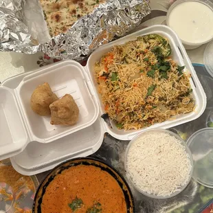 Garlic naan, vegetable samosa, chicken biryani, butter chicken, and white rice