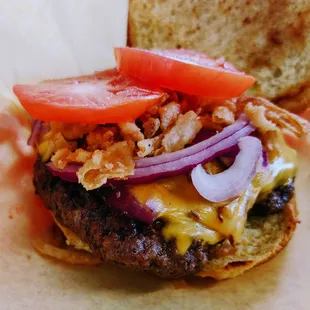 a cheeseburger with tomatoes and onions