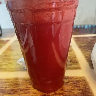 a red drink in a plastic cup