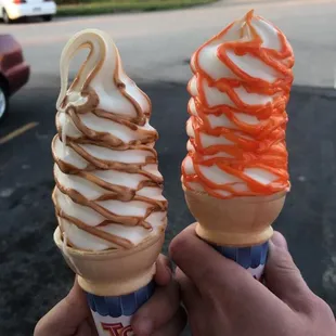 two people holding ice cream cones