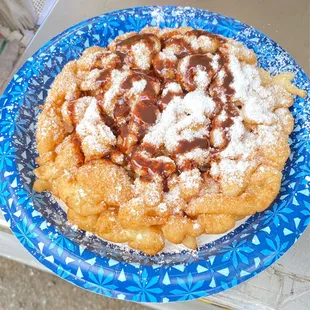 Funnel Cake, dusted with Powdered sugar and drizzled Chocolate, Deliciously light Super Yums the edges crispy