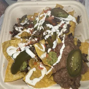 The trash Super Nachos I received with barely any toppings for $13