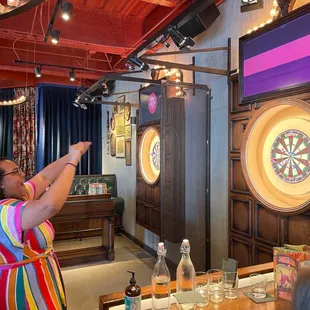 a woman shooting a dart at a target