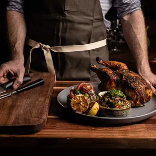 A dramatic wood oven roasted Mary&apos;s chicken dripping with flavor, carved at your table