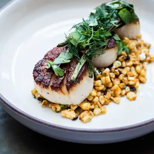 Flint&apos;s scallops on a bed of charred corn salad feature smoky, savory, Mediterranean seafood flavors that melt in your mouth.