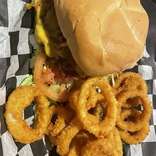 a burger and onion rings on a checkered paper