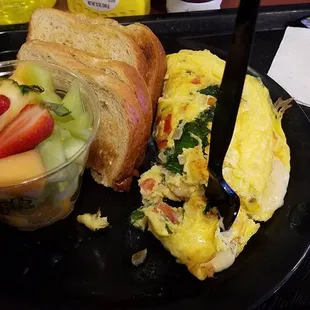 veggie omelet, complete with a fruit cup and toast.