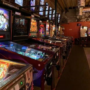a row of pinball machines in a game room
