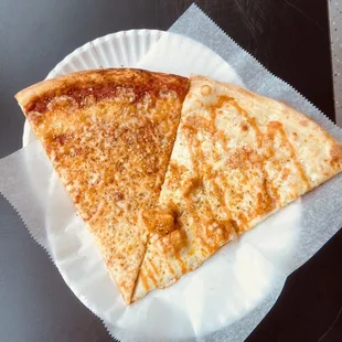 wo slices of pizza on a paper plate
