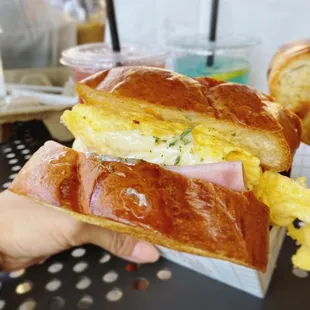 a person holding a sandwich in their hand