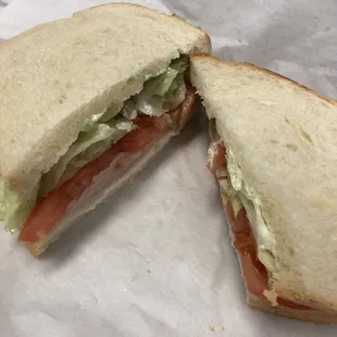 Turkey sandwich on white with lettuce and tomato and mayo