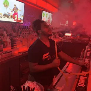 a man standing at a bar with smoke coming out of his mouth