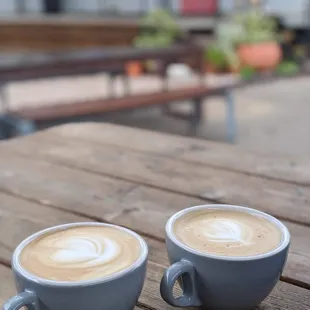 two cups of coffee on a wooden table