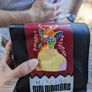 a hand holding a bag of coffee