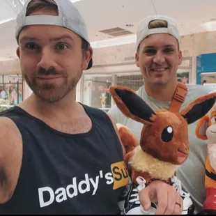 two men holding stuffed animals