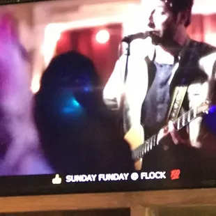 a man playing a guitar on a tv screen