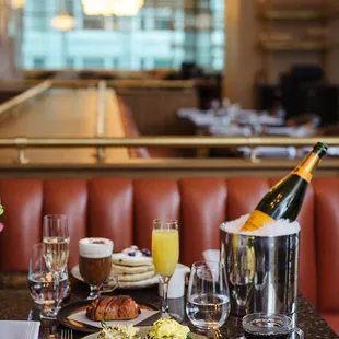 a table with a bottle of champagne and a plate of food