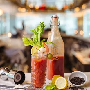 a table with a bottle of alcohol, a cocktail shaker, and a garnished garnish