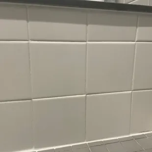 a white tiled bathroom with black grout