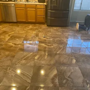 a kitchen with marble flooring and stainless steel appliances