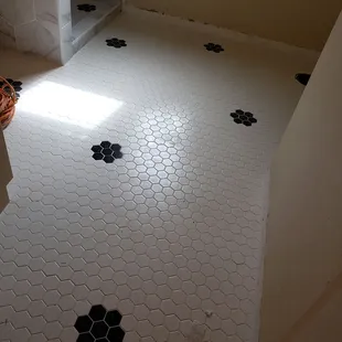 a white bathroom with black and white hexagon tiles