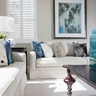 a living room with white couches and a black coffee table