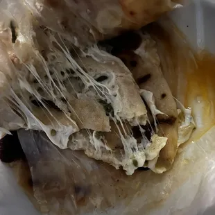 This is two pupusas completely torn apart and half of the cheese was stuck on the wax paper