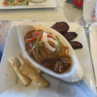 Ropa vieja with a side of fried yucca sticks and plantain