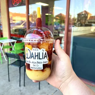 a hand holding a cup of iced coffee