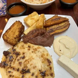 Pupusa Revuelta, tamal de elote frito, yuca, frijoles, queso y crema. Curtido y salsa