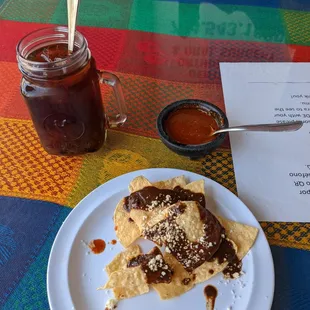 Freshly made chips covered with mole and pumpkin drink. So