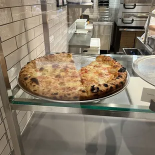a pizza in a glass case