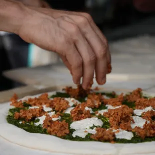 Making a Pesto Royale:

- Local basil pesto
- Cashew not-goat cheese 
 - Seitan &amp; bulgar wheat sausage
 - Marinated bell peppers
