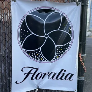 a black and white sign on a fence
