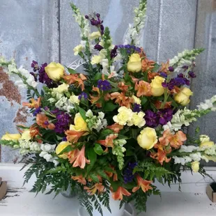 Handled basket funeral  tribute. Snap dragons, roses and alstroemeria.
