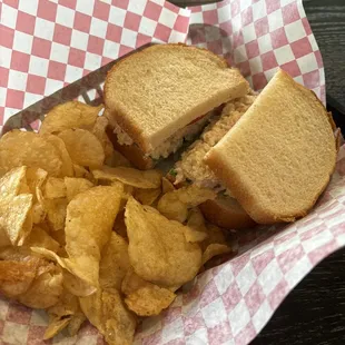 Tuna sandwich on white with a side of homemade chips.