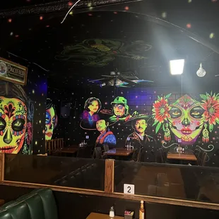 a mural of sugar skulls on the wall