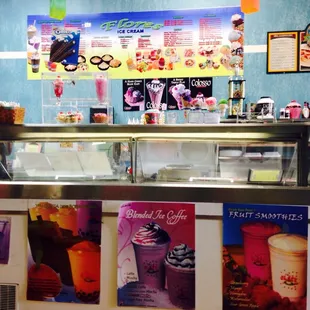 an ice cream counter with posters on the wall