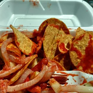 Tostilocos (cueritos, cucumber, chips, Tamarindo candy, cacahuetes Japanese, churros, chamoy, tapatio). A delicious Mexican snack.