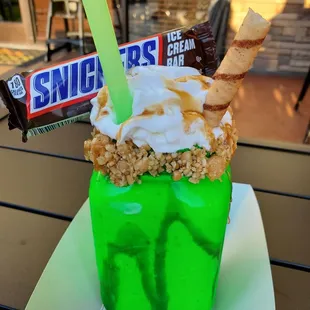 a green cup filled with ice cream and candy