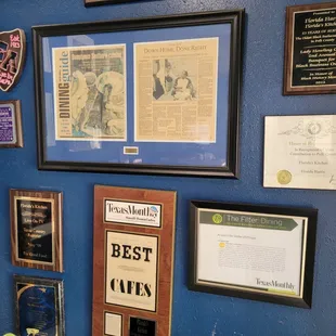 a blue wall with a variety of plaques