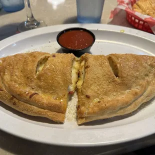 White calzone with pepperoni and marinara sauce.