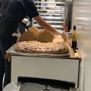 a man making a pizza in a commercial kitchen