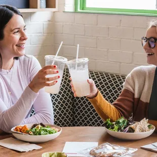 two women sitting at a table having a meal