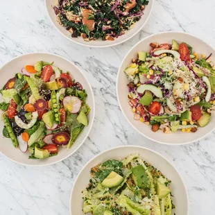 three bowls of salads on a marble table